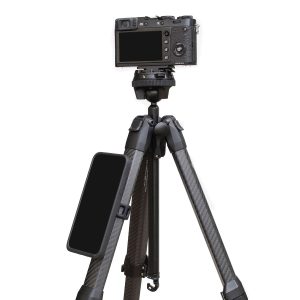 Digitaalikamera on jalustalla, ja älypuhelin on kiinnitetty yhteen hiilikuitujaloista mustalla Peak Design Mobile Universal Bar Mount -kiinnikkeellä.