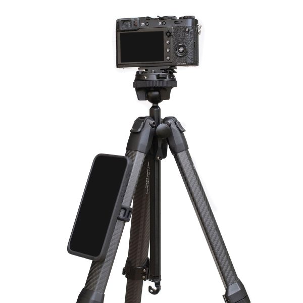 Digitaalikamera on jalustalla, ja älypuhelin on kiinnitetty yhteen hiilikuitujaloista mustalla Peak Design Mobile Universal Bar Mount -kiinnikkeellä.