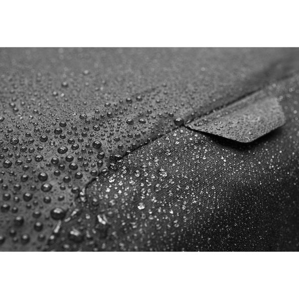 Lähikuva vesipisaroista Peak Design Rain Flyn kuvioidulla, tummalla pinnalla, joka korostaa sen vedenkestäviä ominaisuuksia.