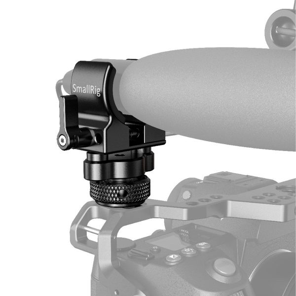 Lähikuva SmallRig 2352 Shotgun Mic Holder (Cold Shoe) -mikrofonipidikkeestä, joka on asennettu kameran häkkiin, jossa on nuppi ja joka on suunniteltu kiinnittämään mikrofonit tukevasti kameran kahvaan.
