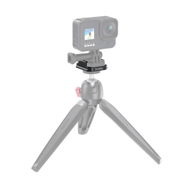 SmallRig 2668 Buckle Adapter with Arca QR Plate for GoPro on asennettu kolmijalkaiseen pöytäjalustaan, jonka näytöllä näkyy surffaava henkilö. Sovitin ja kiinnityslevy ovat tarkennuksessa; jalusta näkyy osittain haalistuneena.