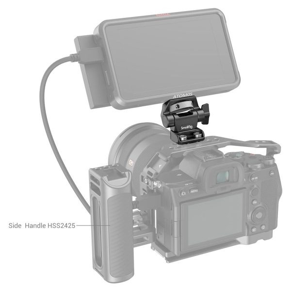 SmallRig 2904 Swivel and Tilt Monitor Mount Screw-Mount -ruuvikiinnikkeellä varustettu digitaalikamera pitää päällä ulkoista monitoria, joka on liitetty kaapelilla. Vasemmalle on asennettu merkitty sivukahva (HSS2425), josta näkyy kameran näyttö ja hallintalaitteet.