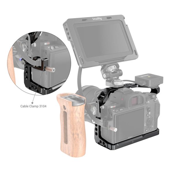 SmallRig-2918-5 SmallRig 2918 Light Cage for Sony A7 III / A7R III / A9 -valaisimessa on näytetty valaisinhäkki, jossa on monitori, puinen sivukahva ja kaapelikiinnike 3104. Sisäkuvassa korostetaan asennetun kaapelipuristimen paikkaa häkissä.