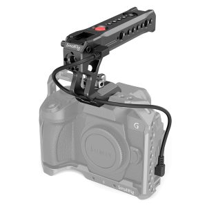SmallRig 3322 NATO Top Handle with Start/Stop Remote Trigger on asennettu häkkiin, joka on kiinnitetty Lumix G -kameraan kaapelilla; kamera ja häkki ovat harmaasävyisiä, mikä korostaa kahvaa.