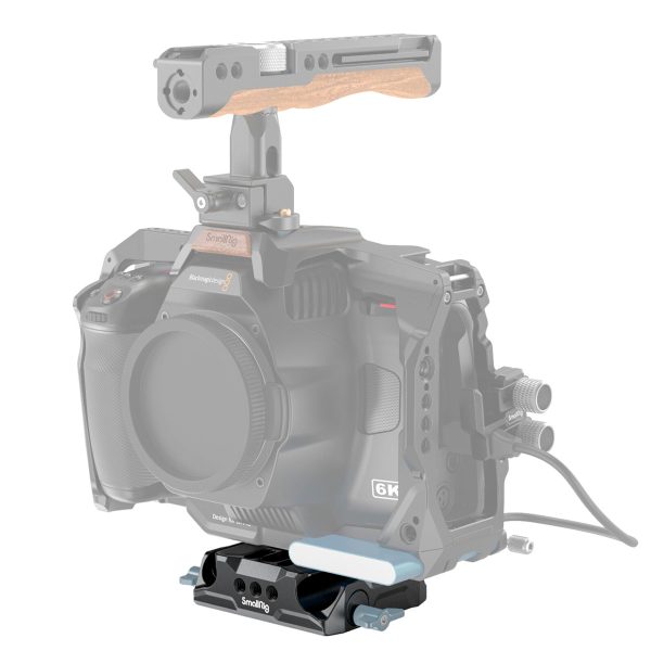 The camera rig features a camera cage, wooden top handle and a black SmallRig 3357 Universal LWS Baseplate with Dual 15mm Rod Clamp, with the camera and some parts faded to highlight the baseplate.