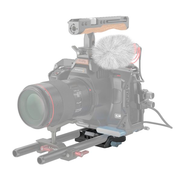 Professional video camera equipment with a large lens, external microphone with grey windscreen, wooden top handle and rods. The partially faded rig highlights the SmallRig 3357 Universal LWS Baseplate with Dual 15mm Rod Clamp and mounting system.