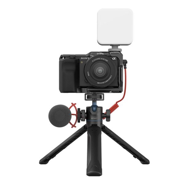 SmallRig 3599 Simorr Vigor VT-15 Vlog Tripod Black -jalustassa on digitaalikamera, vasemmalla puolella kiinnitetty mikrofoni ja päällä neliönmuotoinen valaisin, jotka on yhdistetty punaisilla kaapeleilla.