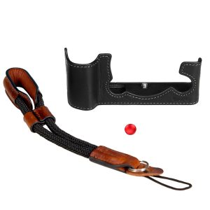 SmallRig 3927 Half Case & Wrist Strap Fujifilm X-T5:lle sisältää mustan nahkaisen puolikotelon, jossa on valkoiset tikkaukset, punotun mustan ja ruskean nahkarannehihnan ja pienen punaisen painikkeen, jotka kaikki näkyvät valkoisella pohjalla.
