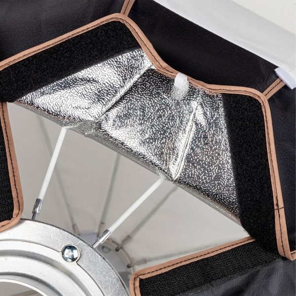 Close-up of the inside of the SmallRig 3932 RA-L90 Lantern Softbox, showing the silver-coloured glossy reflective material, black fabric edges, velcro strips, white rubber bands and metal rod rings.