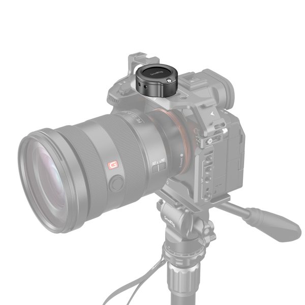 The grey-toned digital camera with a large lens is on a stand with a SmallRig 4149 Cage for Apple AirTag, which securely mounts the device above the camera.