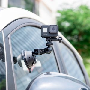SmallRig 4193 Portable Suction Cup Mount SC-1K kiinnittää toimintakameran auton ikkunaan. Taustalla näkyy sumeaa vehreyttä ja osa rakennuksesta.