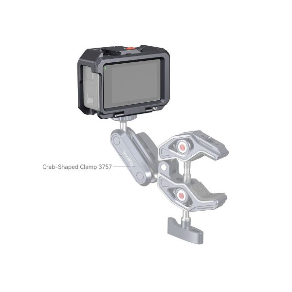 Digitaalinen kamera on kiinnitetty mekaaniseen varteen, joka on kiinnitetty SmallRig 4119 Cage for DJI Osmo Action 3 / 4. Häkki on säädettävissä ja suunniteltu pitämään kamera turvallisesti eri pinnoilla.