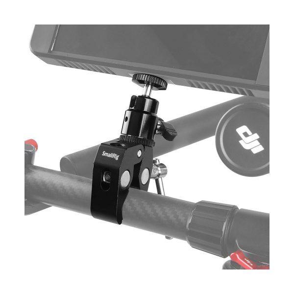 Lähikuva SmallRig 1138 Multi-function Super Clamp -monitoimipuristimesta, jossa on kaksinkertaiset kuulapäät ja 1/4 tuuman ruuvi kiinnitettynä hiilikuitutankoon, joka tukee monitoria - ihanteellinen lisävarusteiden kiinnittämiseen video- tai valokuvausasennuksissa.