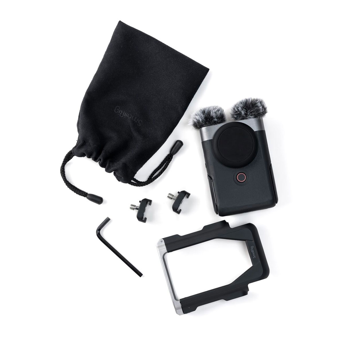The Canon PowerShot V10 Advanced Kit silver compact camera, two hairy windscreens, a black drawstring bag, a metal body mount, an L-shaped Allen key and two mounting adapters are featured on a white background.