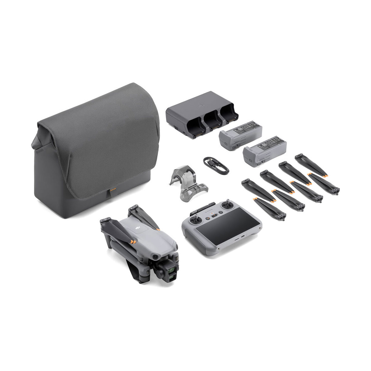 DJI Air 3 (DJI RC 2) Fly More Combo -dronipakkaus on esillä valkoisella pinnalla, jossa on harmaa kantolaukku, taitettu drone, kauko-ohjain, akut, potkurit, latauskeskitin, kaapelit ja lisätarvikkeet.