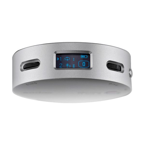 The Godox R1 is a round, silver-coloured electronic device with a small rectangular digital display with blue icons and numbers and two black control dials next to it.