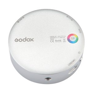 The Godox R1 is a round, silver device with labelled buttons, ports, an RGB light indicator and printed text with certification markings.