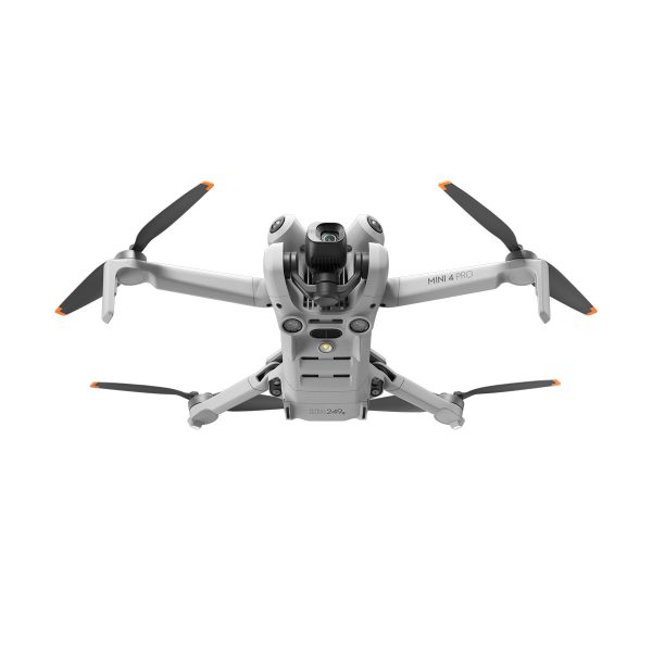 Hopeanvärinen DJI Mini 4 Pro -lennokki, jossa on neljä oranssilla kärjellä varustettua potkuria ja etukamera, näkyy lennossa valkoista taustaa vasten.