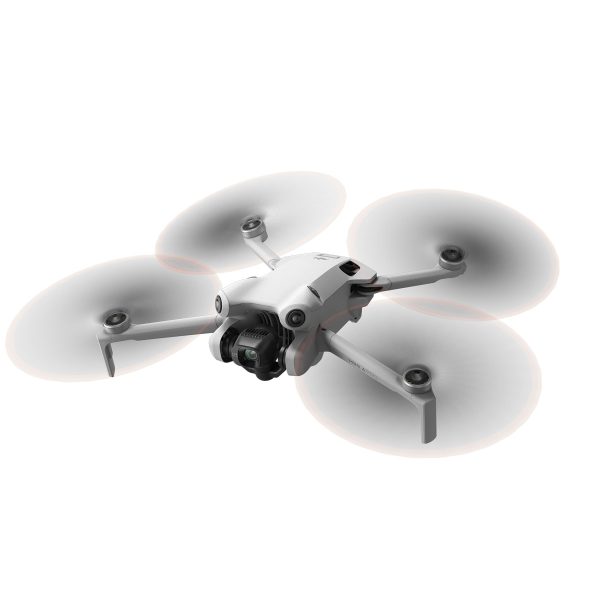 DJI Mini 4 Pro -lennokki, valkoinen nelikopteri, jossa on neljä potkuria ja asennettu kamera, näkyy kesken lennon valkoista taustaa vasten.