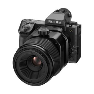 Musta Fujifilm-digitaalikamera, jossa on Fujinon GF 110mm f/5.6 T/S -objektiivi ja jossa on erilaisia painikkeita ja valintakiekkoja, näkyy valkoisella taustalla.