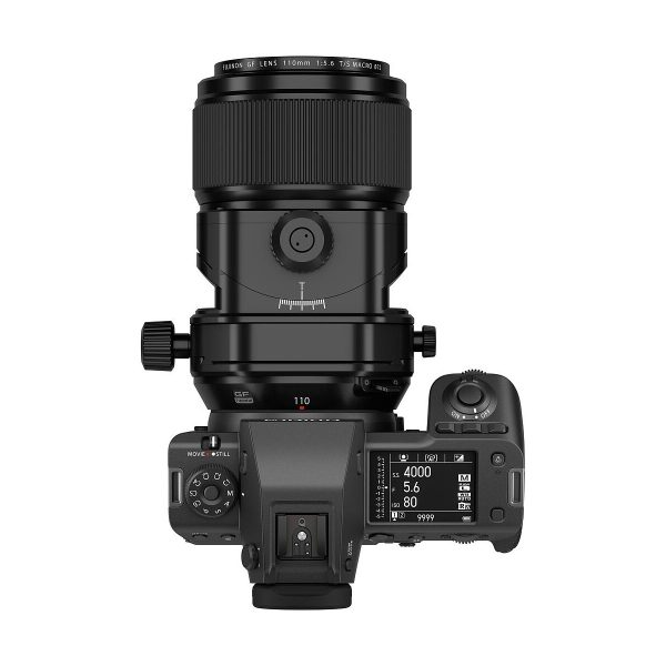 Ylhäältä katsottuna Fujifilm Fujinon GF 110mm f/5.6 T/S -objektiivi kiinnitettynä digitaalikameraan, jossa näyttö ja säätimet näyttävät ISO-, aukko- ja suljinaika-asetukset tavallista valkoista taustaa vasten.