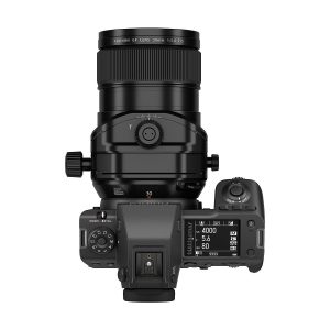 Ylhäältä katsottuna musta digitaalikamera, johon on kiinnitetty Fujifilm Fujinon GF 30mm f/5.6 T/S -objektiivi; näytöllä näkyvät kameran asetukset, ja rungossa on useita valintakiekkoja ja painikkeita valkoista taustaa vasten.