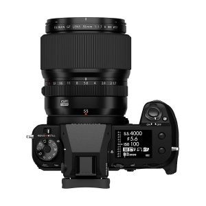 Top view of a black Fujifilm camera with a Fujinon GF 55mm f/1.7 R WR lens attached, with control dials, buttons and a digital display showing the camera settings.
