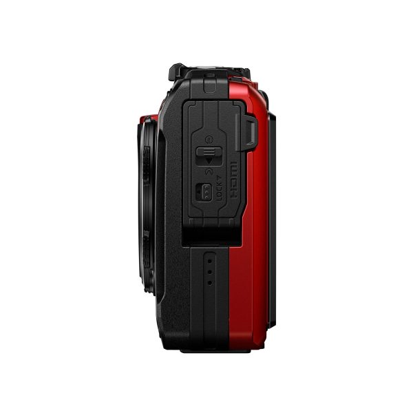 Sivunäkymä OM System Tough TG-7 -kompaktikamera, punainen, osoittaa sen suljettu HDMI ja USB-portit selkeät tarrat, kuvioitu kahva, ja osa objektiivin näkyvissä. Kamera on punainen ja musta valkoista taustaa vasten.