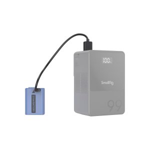 The blue Li-ion battery is connected with a black cable to the grey SmallRig 4330 USB-C rechargeable camera battery NP-FW50, which has a digital display with 100 and the number 99 printed on its minimalist design.