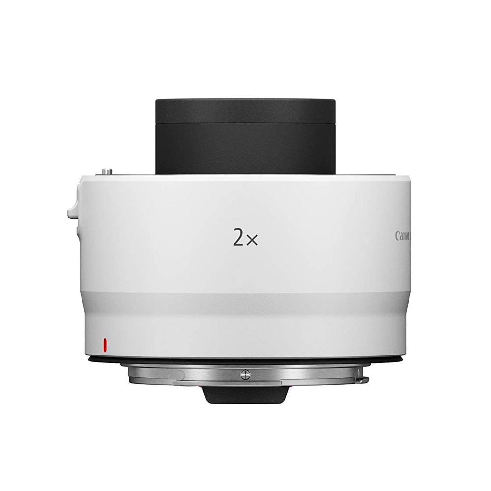 Valkoinen Canon RF Extender 2x näkyy sivulta, jolloin sen lieriön muoto ja metallinen kiinnitysrengas pohjassa korostuvat.
