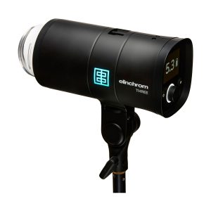 Musta Elinchrom THREE -studiostroboskooppivalaisin jalustalla, jossa on digitaalinäyttö, jossa näkyy 5,3, ja sivusäätöpainikkeet.