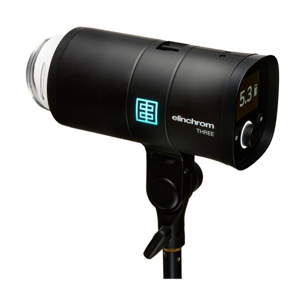 Musta Elinchrom THREE -studiostroboskooppivalaisin jalustalla, jossa on digitaalinäyttö, jossa näkyy 5,3, ja sivusäätöpainikkeet.