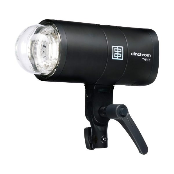 Elinchrom THREE, musta studiostroboskooppivalaisin, jossa on lasinen salamaputki ja säädettävä kahva kannattimella, näkyy valkoista taustaa vasten.