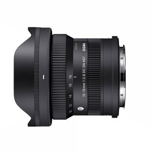 sigma_10-18mm_f28_03 Sigma 10-18mm f/2.8 DC DN -objektiivi, Sony E, sivuprofiili näkyy valkoisella taustalla, jossa näkyy sen musta viimeistely, zoomaus- ja tarkennusrenkaat, vastavalosuoja ja kiinnitys.