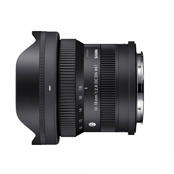 sigma_10-18mm_f28_03 Sigma 10-18mm f/2.8 DC DN -objektiivi, Sony E, sivuprofiili näkyy valkoisella taustalla, jossa näkyy sen musta viimeistely, zoomaus- ja tarkennusrenkaat, vastavalosuoja ja kiinnitys.