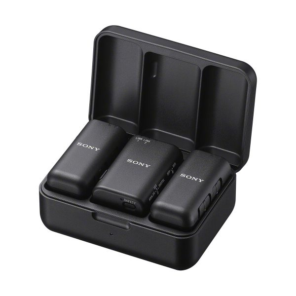 The black charging case is opened and inside are three compact Sony ECM-W3 wireless microphone units.