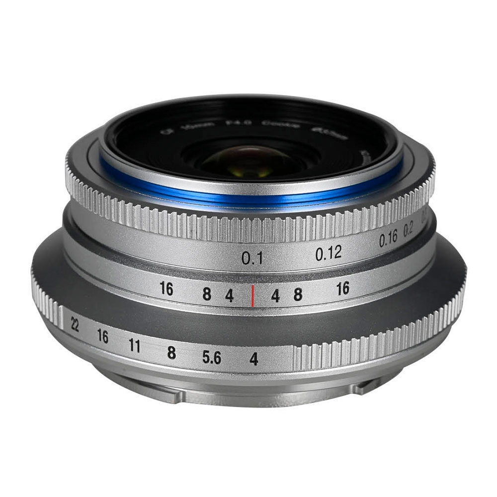 Lähikuva Laowa 10mm f/4 Cookie Silver (L-mount) -objektiivista, jossa on kaiverretut aukko- ja tarkennusnumerot, metallinen viimeistely ja erottuva sininen korostusrengas etulasiosan lähellä.