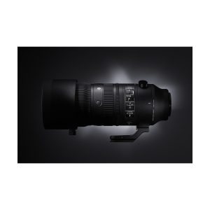 sigma_70-200_sport_dn_01 Sigma 70-200mm f/2.8 DG DN OS Sport -objektiivi Sony E:lle on esillä tummalla kaltevuusasteikollisella taustalla, ja sen tyylikäs musta runko ja sisäänrakennettu jalustakiinnitys korostuvat taustavalossa.