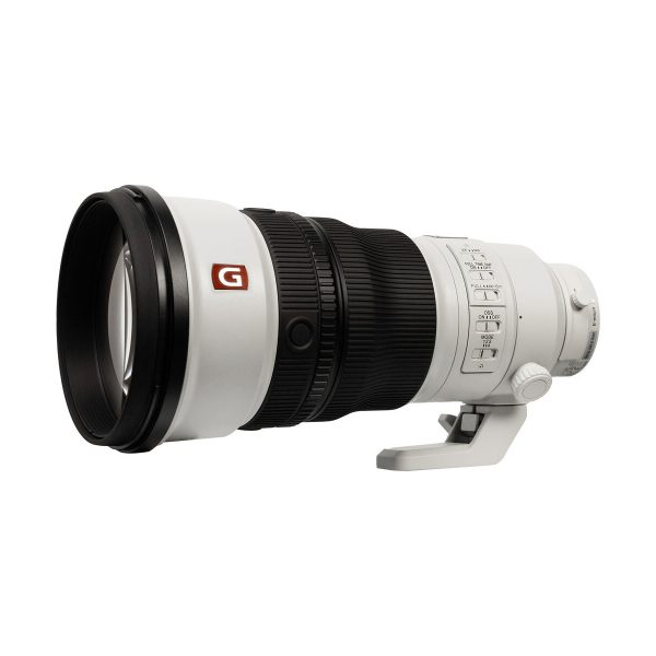 Sony FE 300mm f/2.8 GM OSS -objektiivi on suuri valkoinen teleobjektiivi, jossa on musta kuminen kahva, säätökytkimet, jalustakiinnitys ja G-logo, joka symboloi sen korkealaatuisuutta.