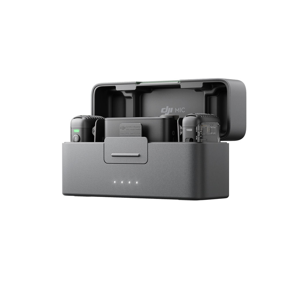 DJI Mic 2 Dual Kit -langaton mikrofonijärjestelmän latauskotelo on avattu, ja sen sisällä on kaksi mikrofonia ja vastaanotin, ja sen kompaktin harmaan muotoilun etupuolella on neljä valaistua merkkivaloa.