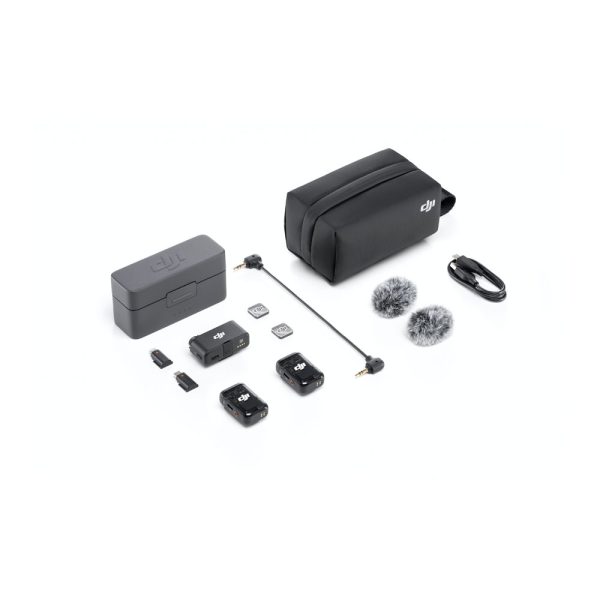 DJI Mic 2 Dual Kit -langaton mikrofonijärjestelmä näkyy valkoisella pinnalla, jossa on kaksi lähetintä, yksi vastaanotin, latauskotelo, kaksi karvaista tuulilasia, USB-kaapelit, sovitinkaapelit, microSD-kortit ja musta kantolaukku.