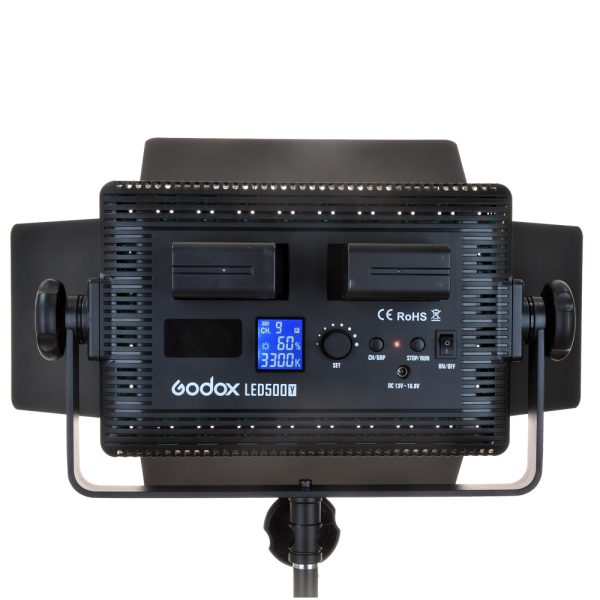 Godox LED 500W Daylight with Barndoor, rear view showing the control panel with digital display, battery positions, control knobs and mounting accessories on a stand.