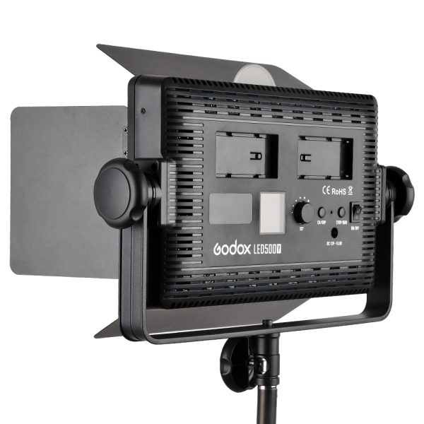 1448269121_407 The Godox LED 500Y Tungsten video light panel with adjustable barn doors, control buttons and two battery compartments is mounted on a light stand and viewed from the rear.