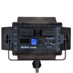 Rear view of the Godox LED 500C Bi-Color, showing the two battery positions, adjustable barn doors, control panel and LCD display showing the settings, mounted on the luminaire base.