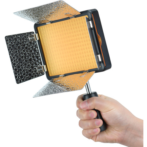 Kädessä on Godox Led LF308D, kannettava LED-paneelivalaisin, jossa on metalliset lato-ovet, kellertävä diffuusori ja musta kahva - ihanteellinen valokuvaukseen tai videovalaistukseen.