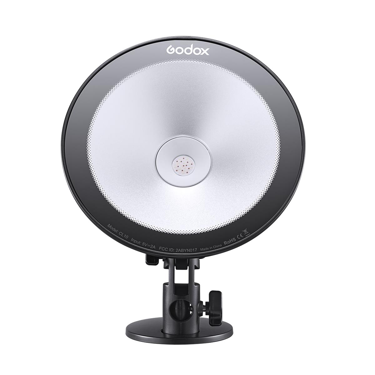 Godox CL10 Ambient LED -valaisimessa on pyöreä muotoilu, jossa on hopeinen heijastin ja musta reunus, ja se on asennettu säädettävään jalustaan, edestäpäin valkoista taustaa vasten.