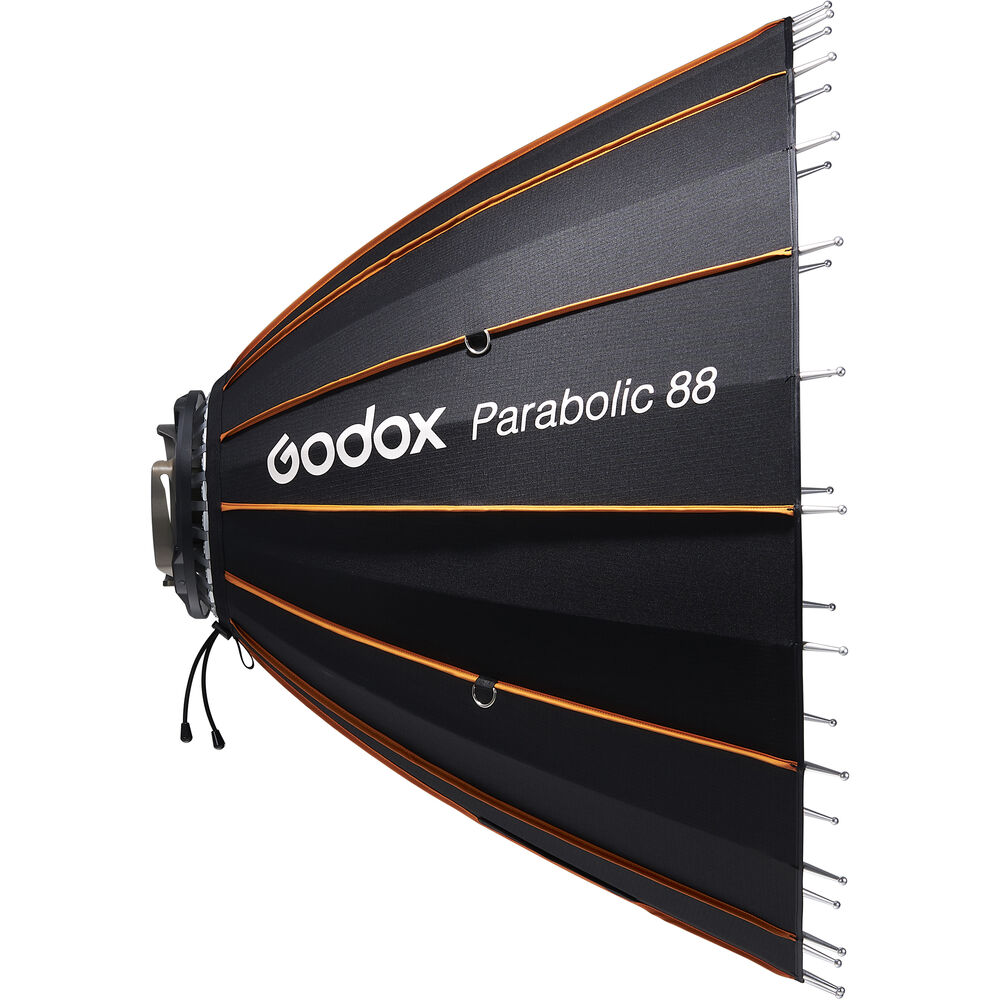 Godox Parabolic Reflector Zoom Box P88Kit, musta parabolinen softbox, jossa on oranssit korostukset, näkyy sivulta, ja sen kankaassa on metalliset tuet ja valkoinen Godox-logo.