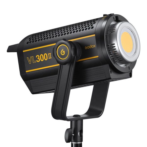 The black and yellow Godox VL300II LED video light is mounted on a tripod, with a power button and large cooling vents in the body.
