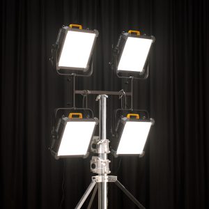 Neljä Godox HJ04 -kiinnikettä, joissa kussakin on oransseilla kahvoilla varustettu P600Bi Hard LED -valaisin, on asennettu metallijalustalle kahteen kahden hengen riviin mustan verhotaustan eteen, ja ne säteilevät voimakasta ja tasaista valoa.