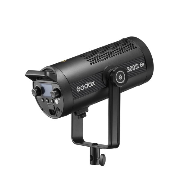 The black Godox SL300IIIBi Bi Color LED Light (300W) with control buttons, display and ventilated body is mounted on a yoke bracket and displayed against a white background.